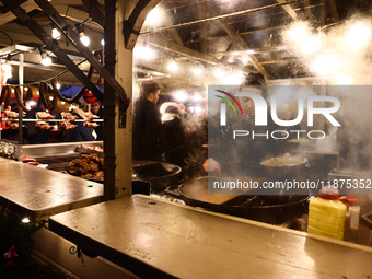 A person prepares food at the Christmas fair at Main Square in Krakow, Poland on December 16, 2024. (