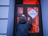 RZESZOW, POLAND - DECEMBER 16:
A woman checking the latest Bitcoin prices through the window of a Bitcoin ATM, on December 16, 2024, in Rzes...