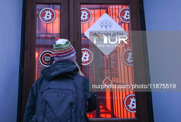 RZESZOW, POLAND - DECEMBER 16:
A woman checking the latest Bitcoin prices through the window of a Bitcoin ATM, on December 16, 2024, in Rzes...