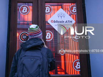 RZESZOW, POLAND - DECEMBER 16:
A woman checking the latest Bitcoin prices through the window of a Bitcoin ATM, on December 16, 2024, in Rzes...