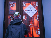 RZESZOW, POLAND - DECEMBER 16:
A woman checking the latest Bitcoin prices through the window of a Bitcoin ATM, on December 16, 2024, in Rzes...