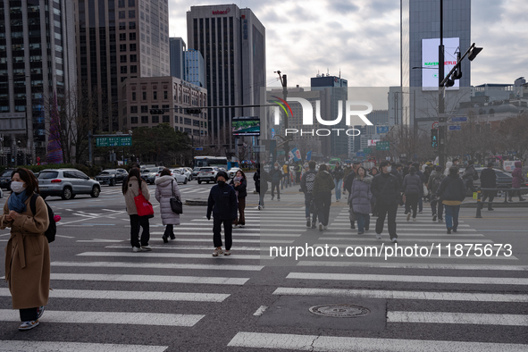 Citizens cross a pedestrian walkway at Gwanghwamun Square in Seoul, South Korea, on December 17, 2024. The city returns to calm following th...