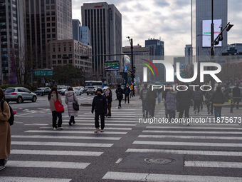 Citizens cross a pedestrian walkway at Gwanghwamun Square in Seoul, South Korea, on December 17, 2024. The city returns to calm following th...