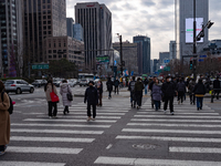 Citizens cross a pedestrian walkway at Gwanghwamun Square in Seoul, South Korea, on December 17, 2024. The city returns to calm following th...