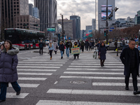 Citizens cross a pedestrian walkway at Gwanghwamun Square in Seoul, South Korea, on December 17, 2024. The city returns to calm following th...