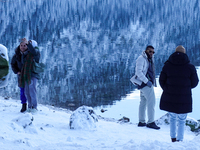 A group of people spends a winter day at Lake Eibsee, located 9 km southwest of Garmisch-Partenkirchen, Grainau, Bavaria, Germany, on Decemb...