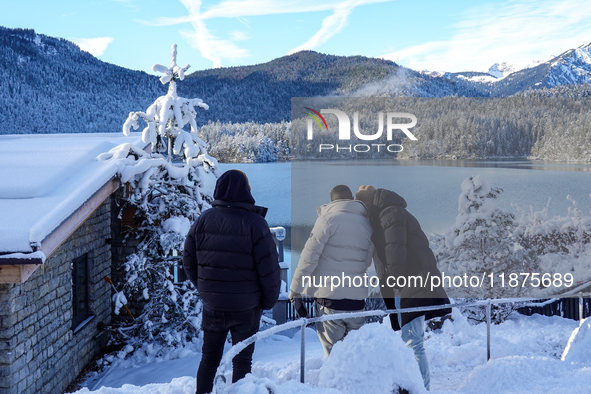 A group of people stands together on a winter day at Lake Eibsee, located 9 km southwest of Garmisch-Partenkirchen, Grainau, Bavaria, German...