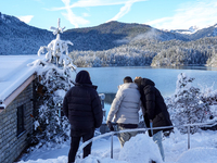 A group of people stands together on a winter day at Lake Eibsee, located 9 km southwest of Garmisch-Partenkirchen, Grainau, Bavaria, German...