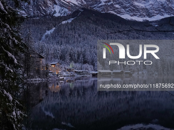 A snowy winter landscape with calm lake reflections appears at Lake Eibsee in Grainau, Bavaria, Germany, on December 13, 2024. A serene twil...