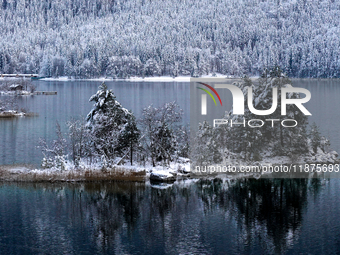 A small island is blanketed in snow at Lake Eibsee in Grainau, Bavaria, Germany, on December 13, 2024. The snow-covered island is surrounded...