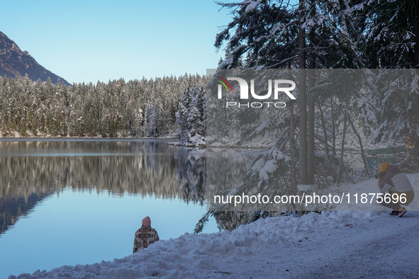 A photographer captures the reflection of snow-covered trees at Lake Eibsee in Grainau, Bavaria, Germany, on December 13, 2024. This winter...