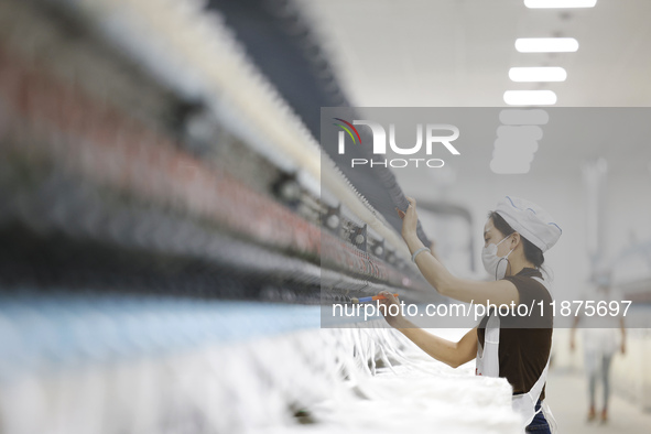 Villagers work at a production workshop of a textile company in Suqian, Jiangsu province, China, on December 16, 2024. 