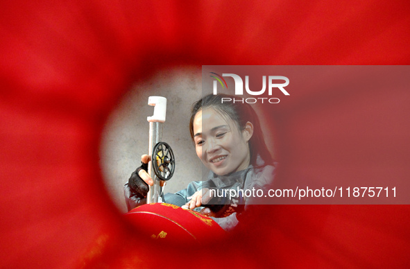 A worker makes red lanterns in Handan, China, on December 17, 2024. 