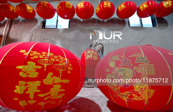 A worker makes red lanterns in Handan, China, on December 17, 2024. 