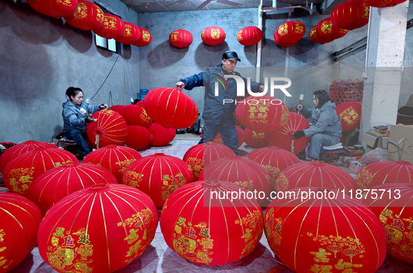 Workers make red lanterns in Handan, China, on December 17, 2024. 