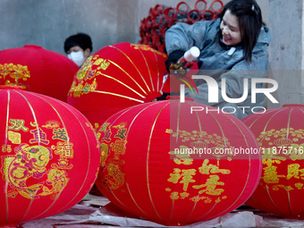 A worker makes red lanterns in Handan, China, on December 17, 2024. (