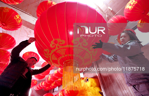 Workers check the quality of red lanterns in Handan, China, on December 17, 2024. 