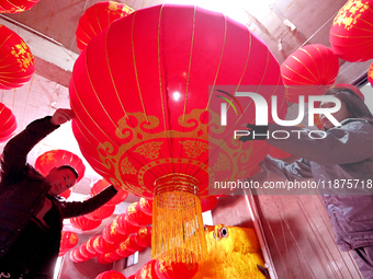 Workers check the quality of red lanterns in Handan, China, on December 17, 2024. (