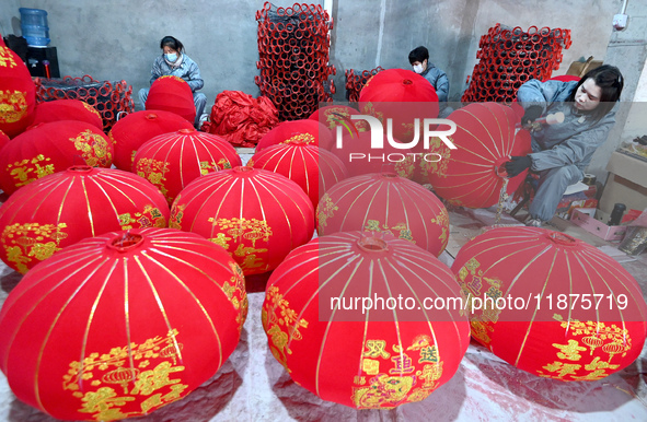 Workers make red lanterns in Handan, China, on December 17, 2024. 