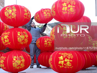 A worker dries red lanterns in Handan, China, on December 17, 2024. (