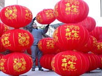 A worker dries red lanterns in Handan, China, on December 17, 2024. (