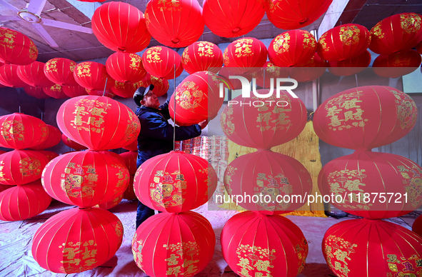 A worker checks the quality of red lanterns in Handan, Hebei province, China, on December 17, 2024. 