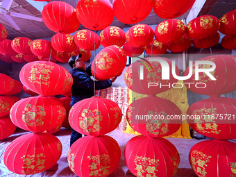 A worker checks the quality of red lanterns in Handan, Hebei province, China, on December 17, 2024. (