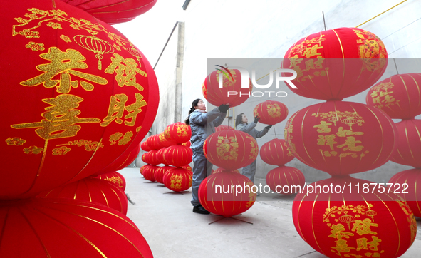 A worker dries red lanterns in Handan, China, on December 17, 2024. 