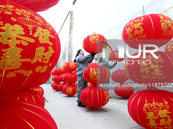 A worker dries red lanterns in Handan, China, on December 17, 2024. (