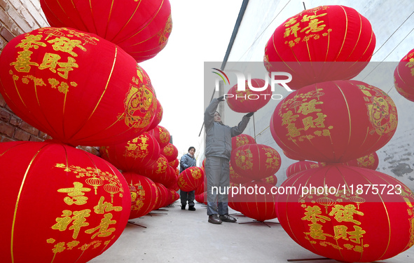 A worker dries red lanterns in Handan, China, on December 17, 2024. 