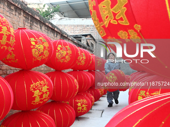 A worker dries red lanterns in Handan, China, on December 17, 2024. (