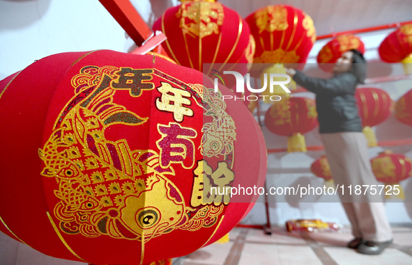 A worker dries red lanterns in Handan, China, on December 17, 2024. 