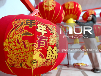 A worker dries red lanterns in Handan, China, on December 17, 2024. (