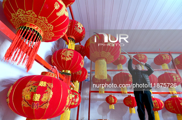 A worker dries red lanterns in Handan, China, on December 17, 2024. 