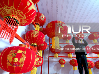 A worker dries red lanterns in Handan, China, on December 17, 2024. (