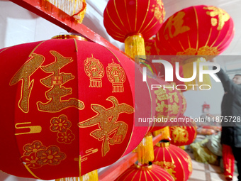 A worker dries red lanterns in Handan, China, on December 17, 2024. (