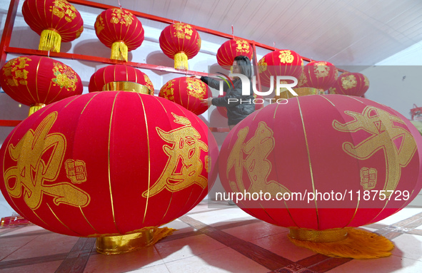 A worker dries red lanterns in Handan, China, on December 17, 2024. 