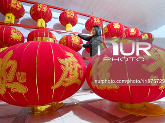 A worker dries red lanterns in Handan, China, on December 17, 2024. (