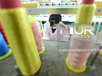 A female worker produces embroidery products for export at a workshop in Lianyungang, China, on December 17, 2024. (