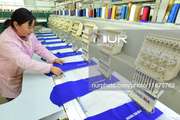 A female worker produces embroidery products for export at a workshop in Lianyungang, China, on December 17, 2024. 