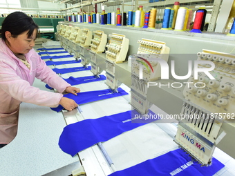 A female worker produces embroidery products for export at a workshop in Lianyungang, China, on December 17, 2024. (