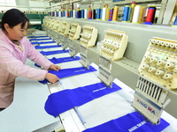 A female worker produces embroidery products for export at a workshop in Lianyungang, China, on December 17, 2024. (