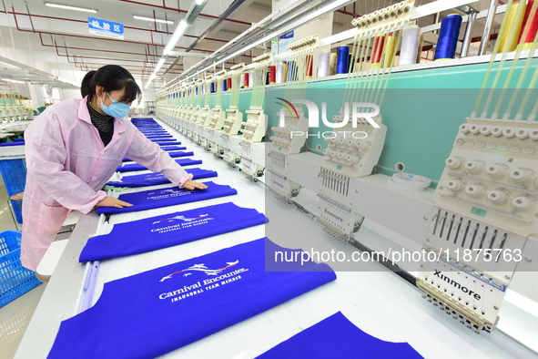 A female worker produces embroidery products for export at a workshop in Lianyungang, China, on December 17, 2024. 