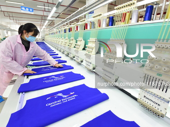 A female worker produces embroidery products for export at a workshop in Lianyungang, China, on December 17, 2024. (