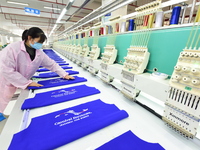 A female worker produces embroidery products for export at a workshop in Lianyungang, China, on December 17, 2024. (