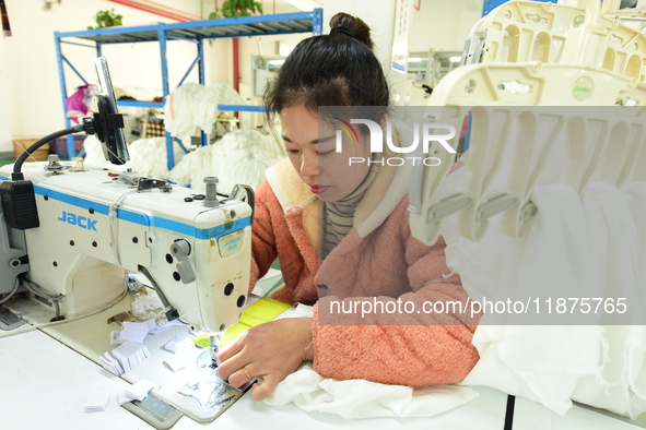 A female worker produces garments for export at a workshop in Lianyungang, China, on December 17, 2024. 