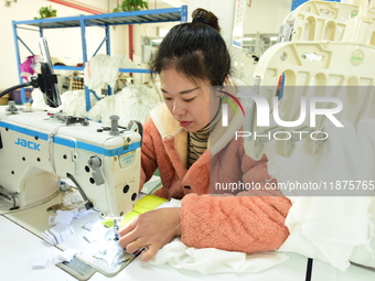 A female worker produces garments for export at a workshop in Lianyungang, China, on December 17, 2024. (