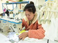 A female worker produces garments for export at a workshop in Lianyungang, China, on December 17, 2024. (