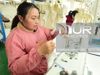 A female worker produces garments for export at a workshop in Lianyungang, China, on December 17, 2024. (