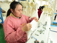 A female worker produces garments for export at a workshop in Lianyungang, China, on December 17, 2024. (